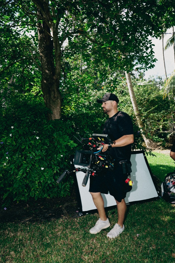 An operator carrying a rigged camera across the location